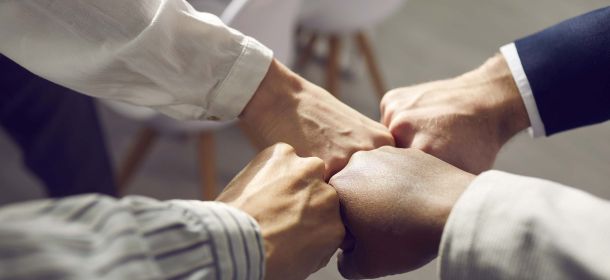 Vier Leute schlagen ihre Fäuste zusammen